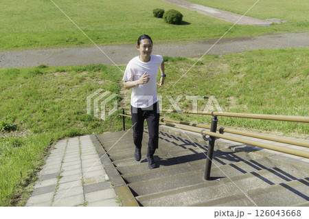多摩川の土手をランニングする若い男性 多摩川の土手をランニングする若い男性 126043668