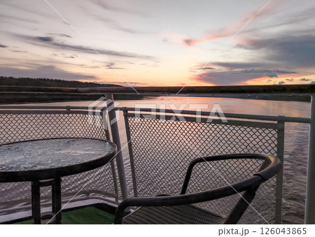 Amazing romantic sunset on the ship deck with table and chairs 126043865