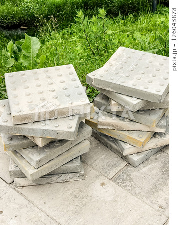 Two stacks of sidewalk tile in the street on a summer day, preparing to repair the pedestrian area 126043878