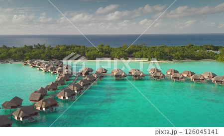 Aerial view of idyllic overwater bungalows in Bora Bora, French Polynesia, set against turquoise lagoon and lush tropical island. Wild travel destination, remote nature paradise, exotic summer travel 126045141