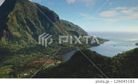 Stunning aerial view showcasing a picturesque bay nestled amidst verdant mountains, turquoise waters, and lush tropical vegetation, capturing the essence of a tranquil paradise in French Polynesia 126045193
