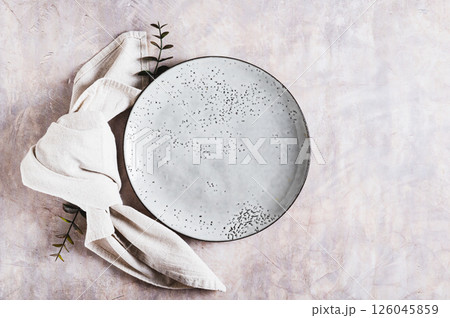 Empty gray ceramic plate and napkin on light background top view 126045859