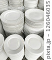 Stacks of clean, white plates ready for use in a commercial setting. 126046035
