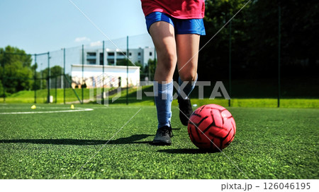 Kid Playing With Football Ball On a Field Kid Playing With Football Ball On a Field 126046195