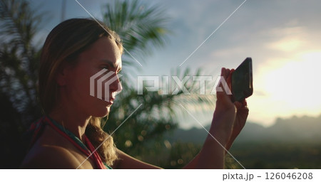 Woman make photo mountain sunset tropical island. Caucasian female tourist portrait hold phone in hands, enjoy outdoor lifestyle travel on summer holiday vacation. Exotic nature landscape. Slow 126046208