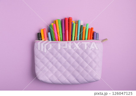 Pencil case with school supplies on purple g background. Top view. Copy space Pencil case with school supplies on purple g background. Top view. Copy space 126047125