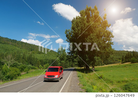 Red car driving on scenic road Red car driving on scenic road 126047649
