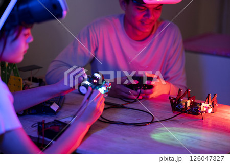Young man and young woman amateur inventor testing electronic device Young man and young woman amateur inventor testing electronic device 126047827