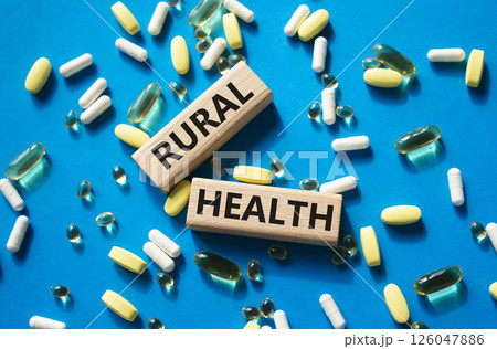 Rural Health symbol. Concept word Rural Health on wooden blocks. Beautiful blue background with pills. Medicine and Rural Health concept. Copy space 126047886