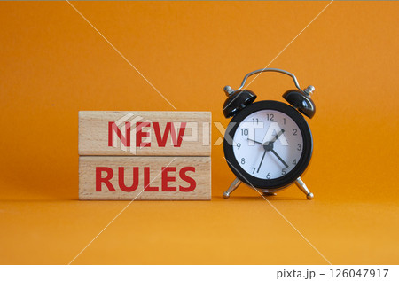 New rules symbol. Concept word New rules on wooden blocks. Beautiful orange background with alarm clock. Business and New rules concept. Copy space 126047917