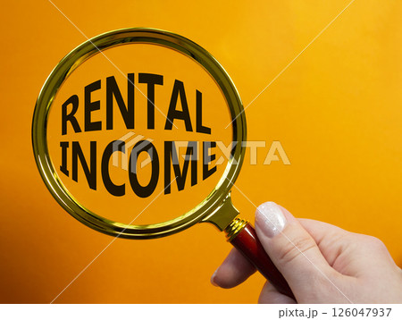 Rental Income symbol. Magnifying glass with words Rental Income. Beautiful orange background. Businessman hand. Business and Rental Income concept. Copy space. Rental Income symbol. Magnifying glass with words Rental Income. Beautiful orange background. Businessman hand. Business and Rental Income concept. Copy space. 126047937