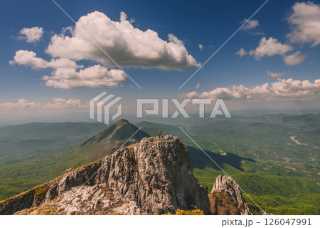 Man Climber Standing on Edge of Mountain Peak 126047991