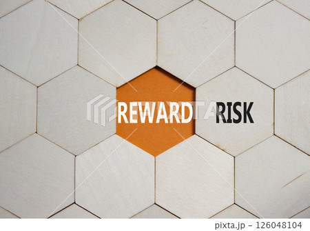 Risk or Reward symbol. Concept word Risk or Reward on wooden comb puzzle. Beautiful orange background. Business and Risk or Reward concept. Copy space Risk or Reward symbol. Concept word Risk or Reward on wooden comb puzzle. Beautiful orange background. Business and Risk or Reward concept. Copy space 126048104