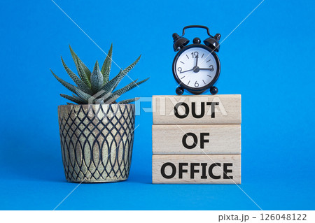 Out of Office symbol. Concept words Out of Office on wooden blocks. Beautiful blue background with succulent plant and alarm clock. Business and Out of Office concept. Copy space 126048122