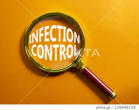 Infection Control symbol. Magnifying Glass with Concept word Infection Control. Beautiful orange background. Business and Infection Control concept. Copy space 126048139