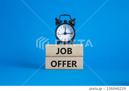 Job Offer symbol. Wooden blocks with words Job Offer. Beautiful blue background with alarm clock. Business and Job Offer concept. Copy space. 126048229
