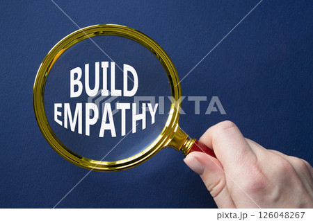 Build empathy symbol. Magnifying glass with words Build empathy. Beautiful deep blue background. Businessman hand. Business and Build empathy concept. Copy space. Build empathy symbol. Magnifying glass with words Build empathy. Beautiful deep blue background. Businessman hand. Business and Build empathy concept. Copy space. 126048267