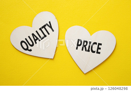 Price or Quality symbol. Concept word Price or Quality on wooden hearts. Beautiful yellow background. Business and Price or Quality concept. Copy space 126048298