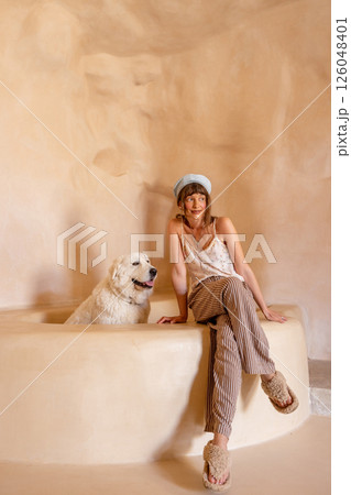 Woman and white dog in sculpted clay bathtub, Sicily Woman and white dog in sculpted clay bathtub, Sicily 126048401