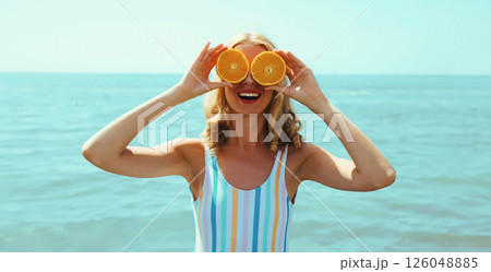 Summer, happy smiling young woman, laughing, with fruits, having fun on the beach on sea background Summer, happy smiling young woman, laughing, with fruits, having fun on the beach on sea background 126048885