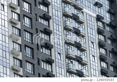 A very tall building featuring numerous windows and multiple balconies 126050583
