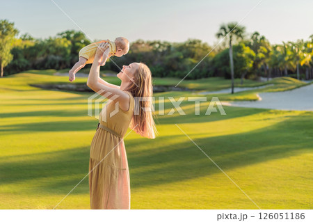Mother and newborn baby on a meadow in the park. Tender bonding moment in nature. Parenthood, love, and family connection concept 126051186