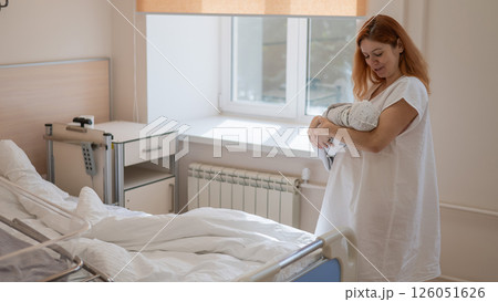 Caucasian woman holding newborn son in maternity hospital ward. Caucasian woman holding newborn son in maternity hospital ward. 126051626