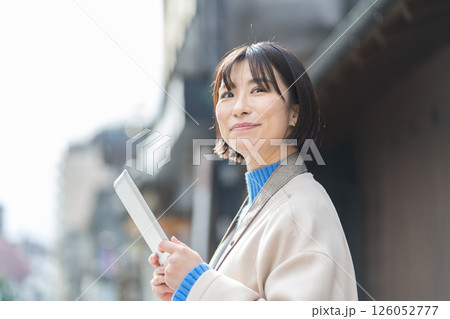 タブレットを操作する女性　タブレットを持って観光する女性 126052777