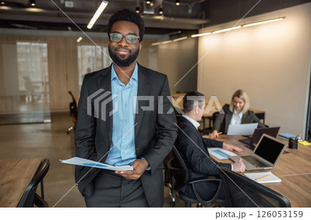 Elegant african american businessman in the office with his colleagues Elegant african american businessman in the office with his colleagues 126053159