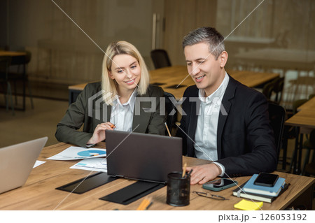 Two colleagues discussing project details and feeling positive 126053192