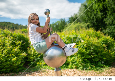 Happy child girl playing on swing on sunny summer day enjoying swinging Happy child girl playing on swing on sunny summer day enjoying swinging 126053246