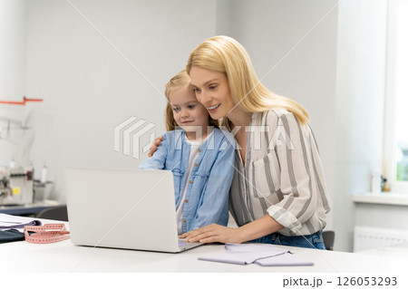 Pretty young caucasian woman in her design studio with her daughter 126053293