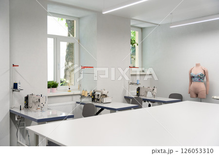 Dress designer studio with sewing equipment and table in the middle 126053310