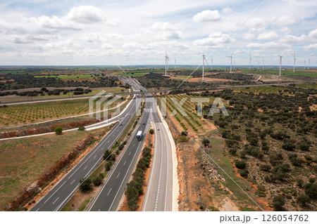 Highway intersection surrounded by wind turbines Highway intersection surrounded by wind turbines 126054762