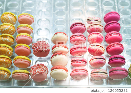 Colorful macarons arranged neatly in a display, showcasing a variety of flavors and textures, perfect for dessert lovers at a bakery Colorful macarons arranged neatly in a display, showcasing a variety of flavors and textures, perfect for dessert lovers at a bakery 126055281