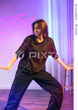 Dynamic contemporary dance performance by a female dancer in a studio with artistic lighting Dynamic contemporary dance performance by a female dancer in a studio with artistic lighting 126055376
