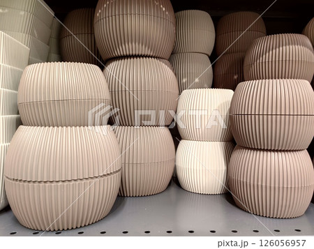 decorative flower pots and planters arranged neatly on store shelf in various shades beige and cream decorative flower pots and planters arranged neatly on store shelf in various shades beige and cream 126056957