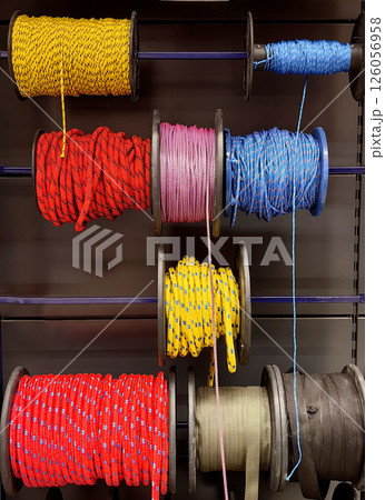 colorful spools rope arranged on shelves in store showcasing various lengths and materials. closeup. colorful spools rope arranged on shelves in store showcasing various lengths and materials. closeup. 126056958