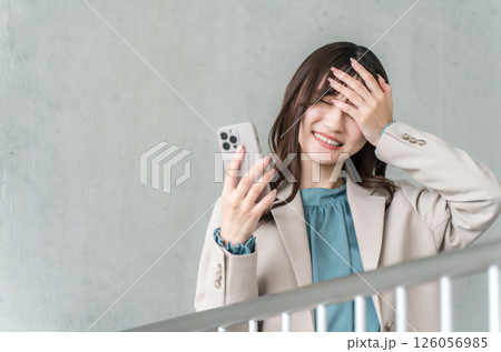 スマホを見て困るスーツ姿の若いアジア人ビジネスウーマン（失敗,ミス,しくじり,詐欺） 126056985