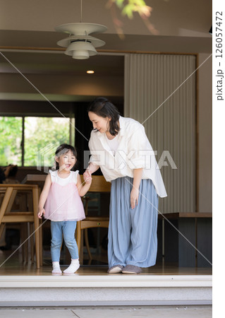 庭先や軒先がある部屋でくつろぐ手を繋ぐ母親と娘(子供)子育ての幸せのイメージ 庭先や軒先がある部屋でくつろぐ手を繋ぐ母親と娘(子供)子育ての幸せのイメージ 126057472