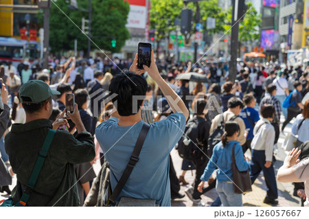 渋谷スクランブル交差点を横断する人たちを撮影する観光客の後ろ姿 渋谷スクランブル交差点を横断する人たちを撮影する観光客の後ろ姿 126057667