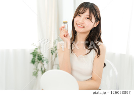 薬・サプリメントの瓶を持つ笑顔のアジア人女性 126058897
