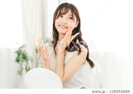 薬・サプリメントの瓶を持つ笑顔のアジア人女性 薬・サプリメントの瓶を持つ笑顔のアジア人女性 126058899