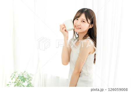朝、家で白湯・コーヒー・ホットドリンク・カフェオレ・カフェラテを飲む笑顔のアジア人女性 朝、家で白湯・コーヒー・ホットドリンク・カフェオレ・カフェラテを飲む笑顔のアジア人女性 126059008