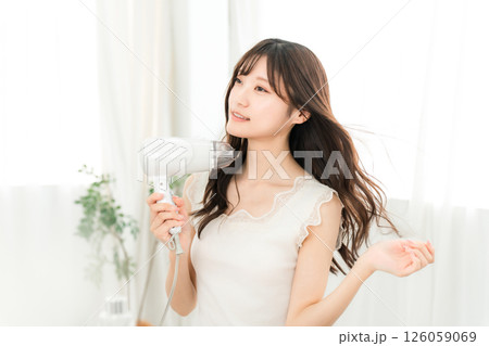 ヘアドライヤーでヘアブロー・髪の毛を乾かす女性(ヘアケア) ヘアドライヤーでヘアブロー・髪の毛を乾かす女性(ヘアケア) 126059069