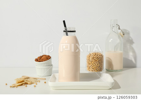 Bottles of alternative milk and herbal ingredients on light background 126059303