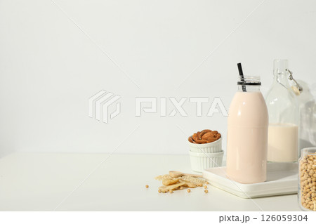 Bottles of alternative milk and herbal ingredients on light background, space for text Bottles of alternative milk and herbal ingredients on light background, space for text 126059304