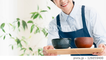 食事を提供する中高年女性 食事を提供する中高年女性 126059400