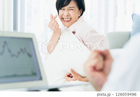 リビングでパソコンを見て喜ぶ中高年夫婦 126059496