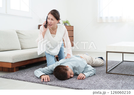 電話で救急車を呼ぶシニア女性 電話で救急車を呼ぶシニア女性 126060210